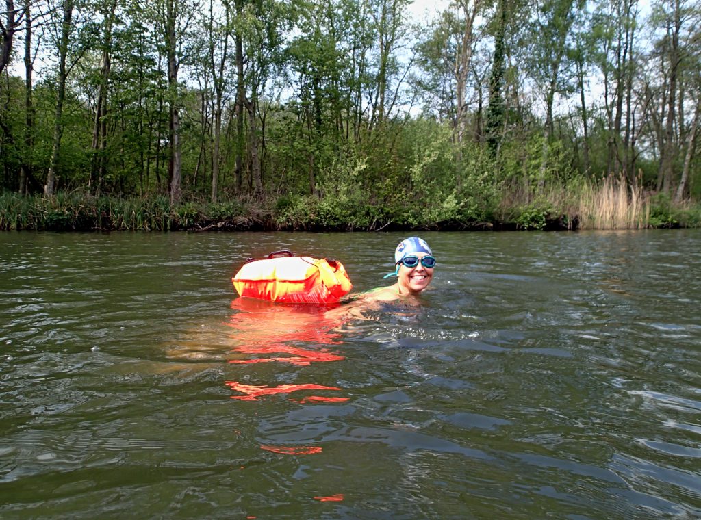 swimmer in river with orange float