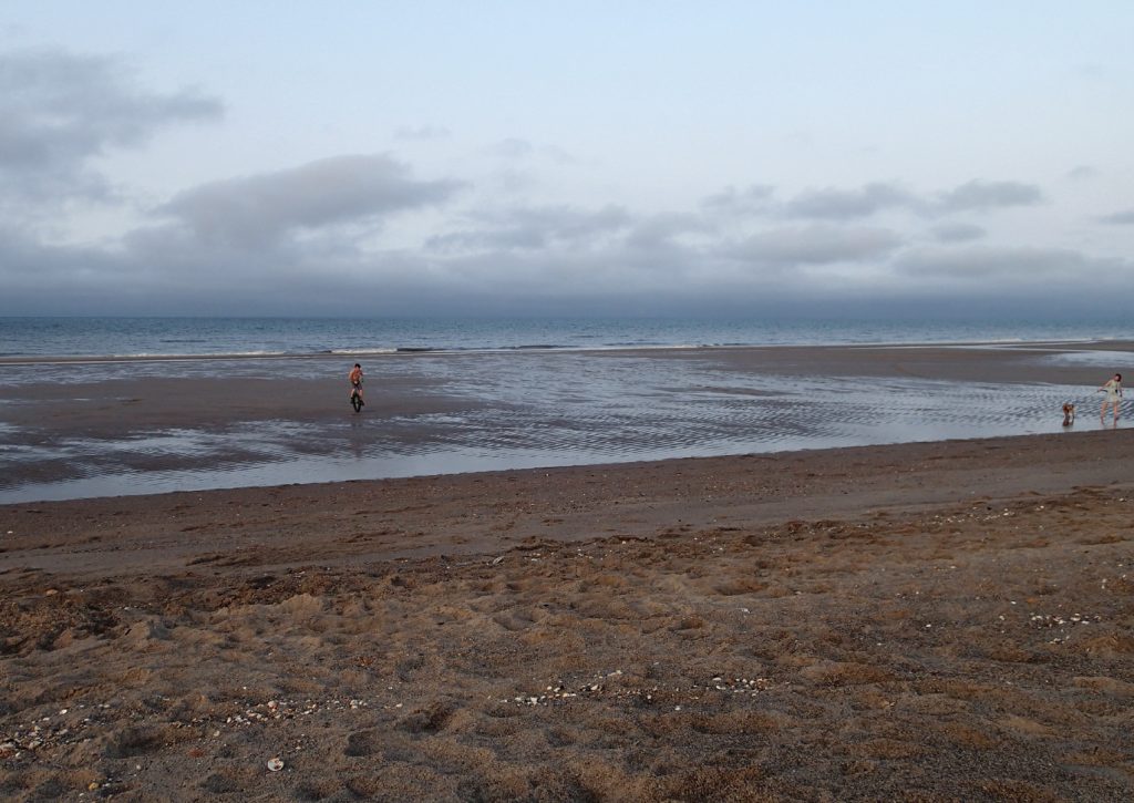 shallow sea with unicycle and woman and child running