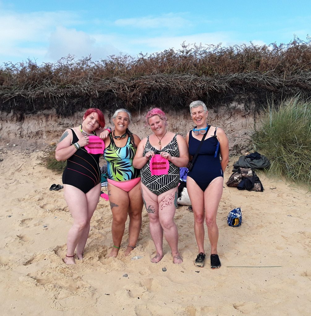 four swimmers on a beach
