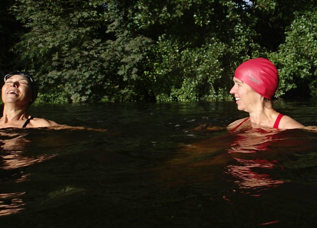 two swimmers smiling in water