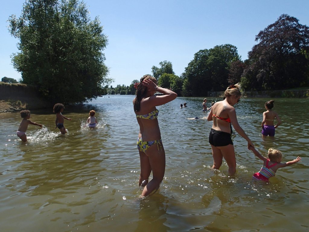 adult and child swimmers in the river