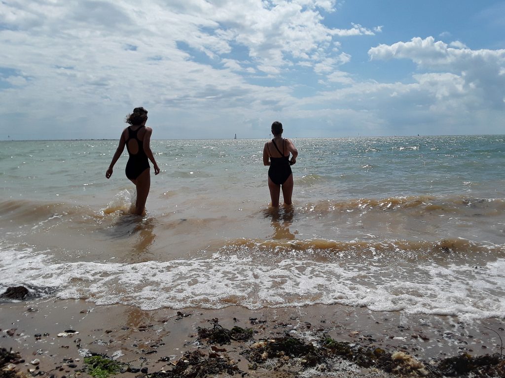 back view of 2 swimmers in sea