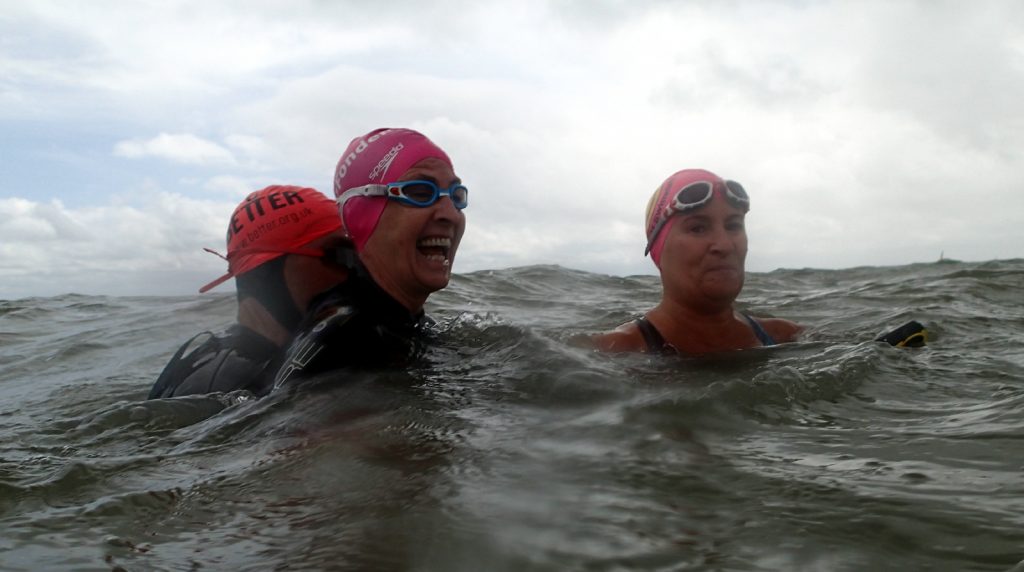 3 swimmers in waves