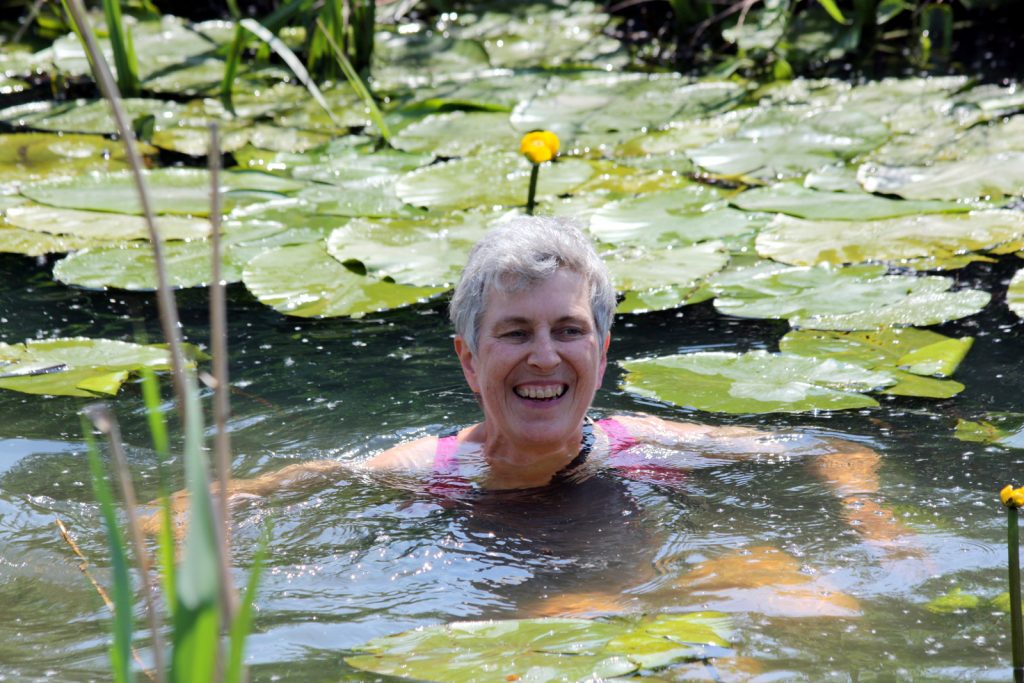 swimmer surrounded by water lilies