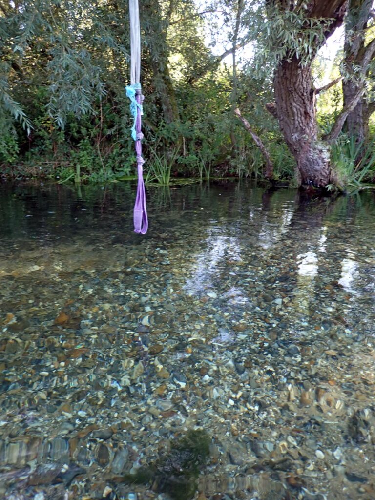 rope swing and clear water with stones