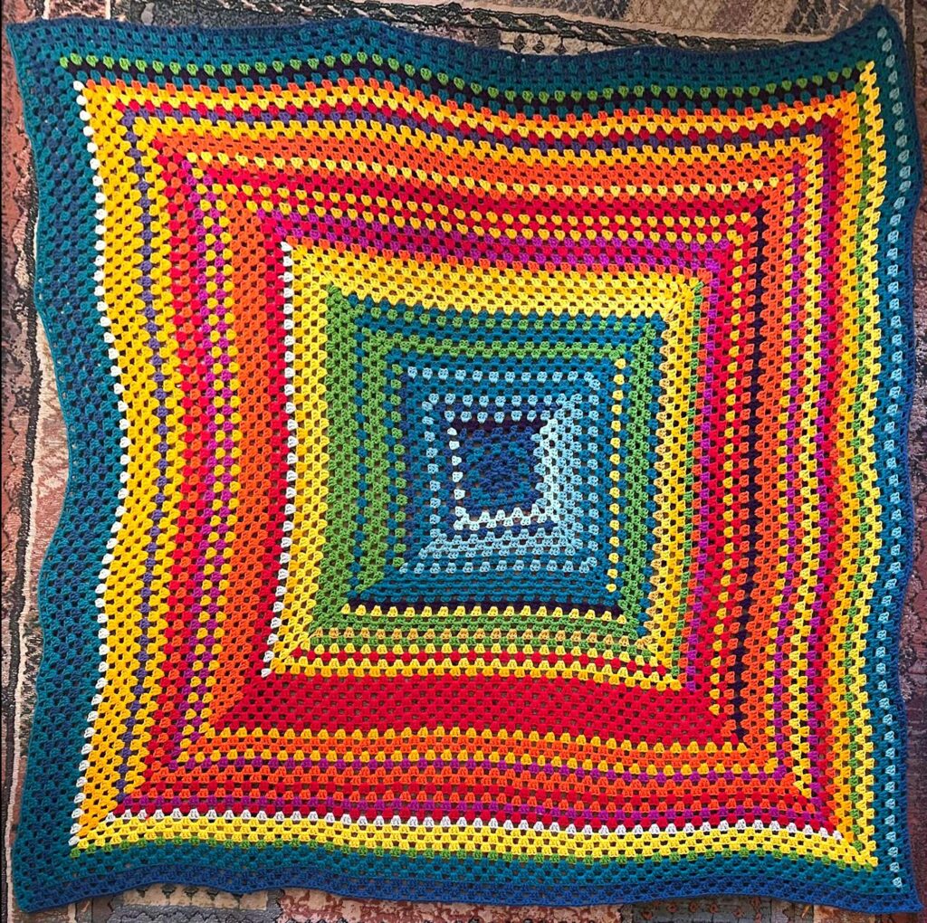 blanket with rows ranging from blue through red, yellow and green and back to blue